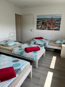 美因茨Apartment in Mainz-Lerchenberg的一间设有三张床的客房,墙上挂着一幅画