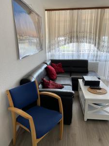 美因茨Apartment in Mainz-Lerchenberg的客厅配有真皮沙发和椅子
