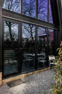 布鲁克因瓦特兰Lovely private cottage near Amsterdam的客房设有带桌椅的大窗户。
