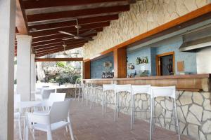 圣蓬萨Paz y Mar, Santa Ponsa的一间设有白色椅子的餐厅和一间酒吧