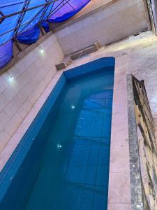 十月六日城فيلا بحمام سباحه的大楼里的一个大型蓝色游泳池
