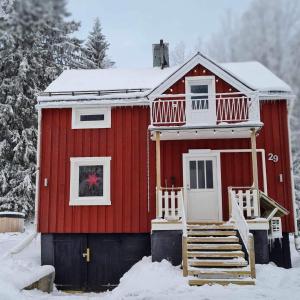 Liebevoll renoviertes Ferienhaus im schwedischen Lappland的雪中的一个红色房子