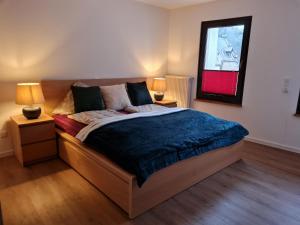 特拉本特拉巴赫Ferienhaus Take it easy的一间卧室配有一张带两盏灯和镜子的床