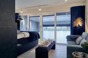 哈尔德韦克Captains Boathouse Studio的一间卧室配有一张床、一张沙发和一个窗口
