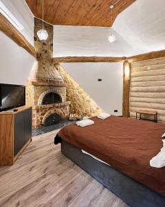 格列博夫卡Ліс&More的一间卧室设有一张大床和一个石头壁炉