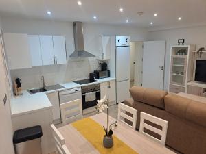 直布罗陀Main Street - 3 Bed Room - Family Friendly的厨房以及带沙发和桌子的客厅。
