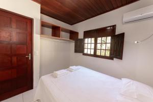 马拉戈日Residencial Maragogi的一间卧室配有一张带白色床单的床和一扇窗户。