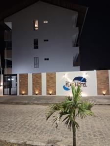 普拉亚多斯卡内罗斯Praia dos Carneiros Flat Hotel Lindo Apto 302的棕榈树在晚上在建筑物前