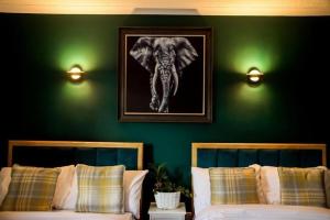 巴洛赫Lomond Park Hotel的一间卧室配有两张床,一张大象的照片