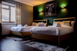 巴洛赫Lomond Park Hotel的绿墙客房内的两张床