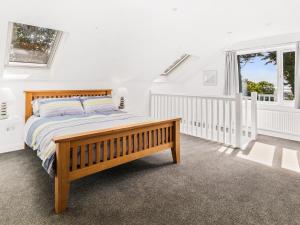 普尔赫利Seaborne Cottage的一间卧室设有一张木床和一个窗户。