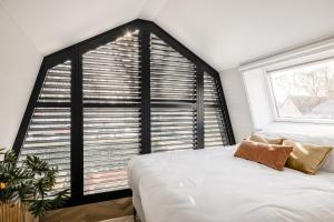 布鲁克因瓦特兰Lovely private cottage near Amsterdam的一间卧室设有一张床和一个大窗户