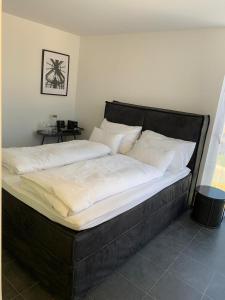 费尔德基希Motel by Maier Feldkirch - kontaktloser Check-in的一张黑色大床,配有白色床单和枕头