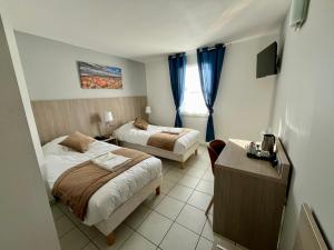 圣马迪拉莫阿卡兹酒店的酒店客房设有两张床、一张桌子和一张书桌。