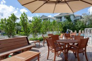 劳德代尔堡Maritime Hotel Fort Lauderdale Airport & Cruiseport的一个带桌椅和遮阳伞的庭院
