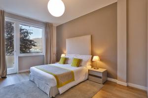 科莫Como Lake Suites的一间卧室设有一张大床和一个窗户。