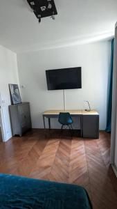佩皮尼昂Appartement 120 m² Standing Hyper Centre Climatisé的客房设有一张桌子、一台电视和一把椅子
