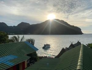 皮皮岛Phi Phi Goodview Bungalow的山上阳光下的水中小船