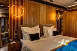 克卢日-纳波卡Hotel Vibre的两张床铺,位于酒店客房,墙上有灯
