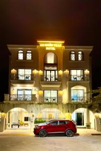Phú MỹAn Nhiên Villa Hotel的停在大楼前的红色汽车