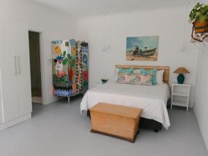 西萨默塞特McLeod's & Stuart's Cottage的白色卧室配有床和桌子