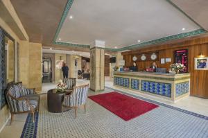 马拉喀什莫加多尔门扎公寓酒店的酒店大堂设有前台和红色地毯