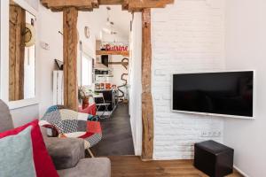 马德里Charming La Latina Home的一间客厅,在白色砖墙上配有电视