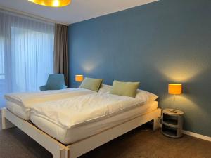 穆尔滕Hotel Bad Murtensee的一间卧室设有一张蓝色墙壁的大床