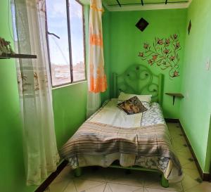 乌尤尼Hostal Golden Quinua的一间位于绿色客房内的卧室,配有一张床