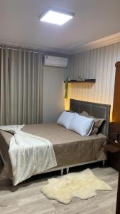 格拉玛多Residencial Don Alfredo-Luxo Gramado 2 km do centro locação de temporada的一间卧室,卧室内配有一张大床