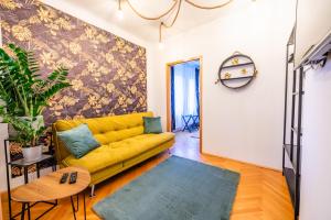 格拉茨Modernes Appartement的客厅里一张黄色的沙发,墙上挂着