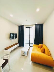顺安Experience Luxury Living! Spectacular 1-Bedroom Apartment in Thuan An, Binh Duong的客厅配有黄色的沙发和桌子