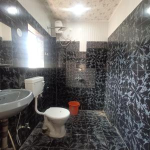 卡兰古特VILLA CASA SUMANJO (3BHK)的黑色瓷砖浴室设有卫生间和水槽