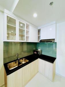 顺安Experience Luxury Living! Spectacular 1-Bedroom Apartment in Thuan An, Binh Duong的厨房配有白色橱柜和水槽