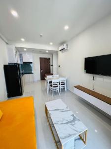 顺安Experience Luxury Living! Spectacular 1-Bedroom Apartment in Thuan An, Binh Duong的客厅配有桌子和墙上的电视