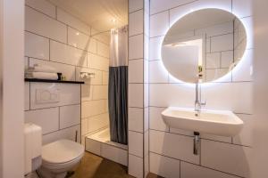 Grubbenvorst赫伯格德林德户夫酒店的一间带水槽、卫生间和镜子的浴室