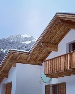 锡贝塔尔Spitzen Blicke – Apartments的一座带雪覆盖的山的建筑中的木制阳台