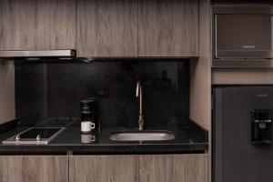 巴兰基亚Amari Living Suites的厨房配有水槽和咖啡壶