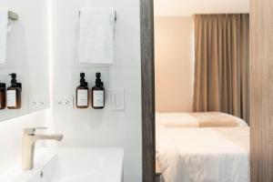 巴兰基亚Amari Living Suites的浴室的墙上装有两瓶葡萄酒