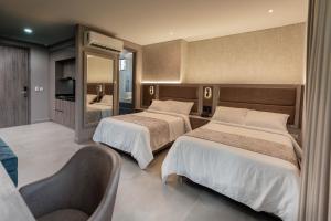 巴兰基亚Amari Living Suites的酒店客房,设有两张床和镜子