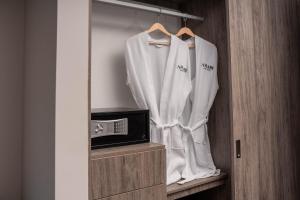 巴兰基亚Amari Living Suites的衣柜配有白色长袍和微波炉