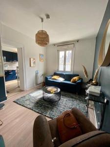 多维尔Studio avec terrasse à Deauville的客厅配有蓝色的沙发和桌子