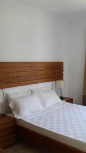 比泰兹Meis Hotel的一张带木制床头板和白色床单的大床