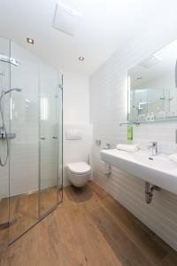 瓦格赖恩雪绒花瓦格自然酒店的浴室配有卫生间、两个盥洗盆和淋浴。