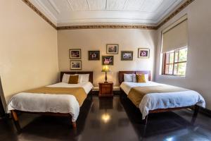 昆卡昆卡酒店的带2扇窗户的客房内的2张床