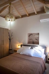 爱琴娜岛Simo's Apartments的一间卧室配有一张大床和一个吊灯。