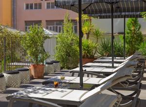 巴塞罗那H10大都会4 *索普酒店的庭院里一排带遮阳伞的桌子
