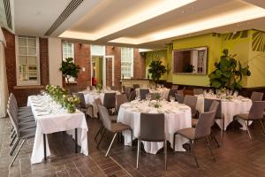 埃克塞特埃克塞特红酒酒店的一间设有白色桌子和椅子的房间,并鲜花