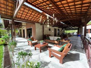 瓜拉米兰加Pousada Monte Flor Guaramiranga CE的一个带桌椅的户外庭院和木制屋顶