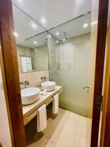 查韦斯Castelo Hotel的一间带两个盥洗盆和大镜子的浴室